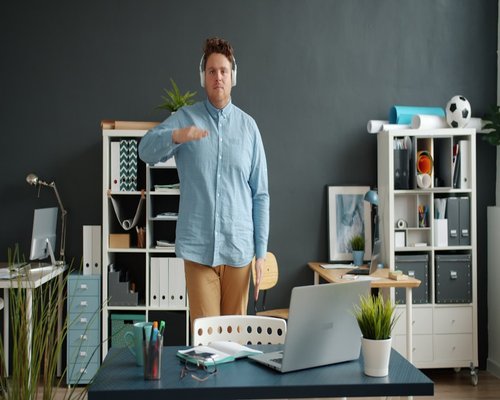 A modern office space with a person standing and stretching slightly