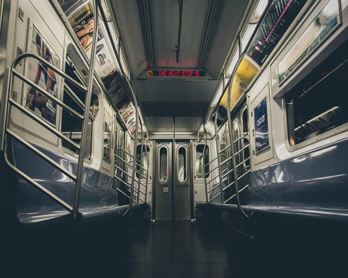 A person standing comfortably holding onto a rail in public transit