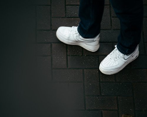 A person wearing comfortable sneakers walking on pavement